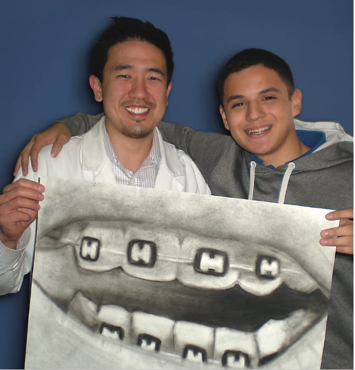 Dr. Chang with a teen patient holding his drawing at Chang Orthodontics