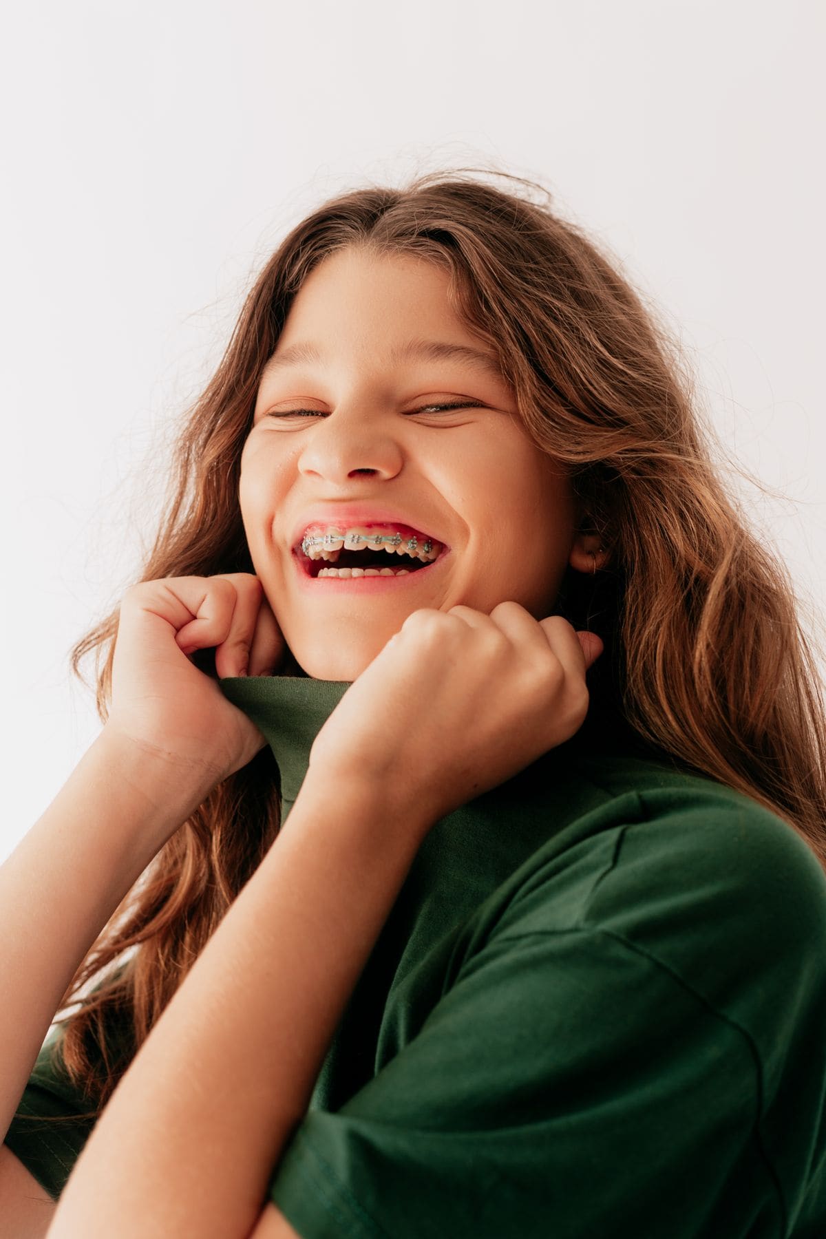 A laughing kid showing off her metal braces